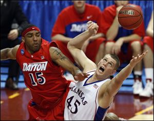 Kansas's Cole Aldrich and Dayton's Charles Little compete for a rebound Sunday in Minneapolis where the Jayhawks' center had 13 points, 20 rebounds and a career-high 10 blocked shots.
Xavier's B.J. Raymond drives to the basket against Wisconsin's Jason Bohannon in an NCAA
second-round game. Raymond, a St. John's Jesuit graduate, led the Musketeers with 15 points.
<br>
<img src=http://www.toledoblade.com/assets/gif/TO1599743.GIF> <b><font color=red>NCAA highlights:</b></font color=red> <a href=