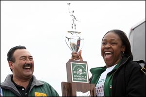Tiffani Blackman shows off the runner-up trophy awarded to the Start High School girls' basketball team. She's with Athletic Director Dan Sanders during welcome-home festivities. 