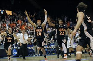 Findlay s Nathan Hyde, left, Morgan Lewis and Josh Bostic chase after Tyler Evans after Evans hit
the game-winning shot Saturday to give Findlay the Division II national championship.