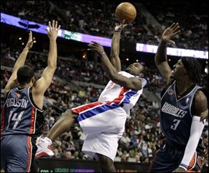 The Pistons' Will Bynum, center, takes a shot against the Bobcats' D.J. Augustin (14) and Gerald Wallace in the second half Sunday in Auburn Hills, Mich. Bynum scored a franchise-record 26 points in the fourth quarter to lead Detroit to a 104-97 victory.