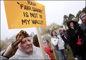 Arthur Graham, a World War II veteran, salutes during the Pledge of Allegiance as a prelude to Toledo s version of Tax Day Tea Party in International Park. 