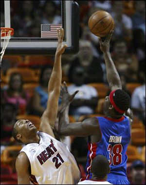 The Pistons  Kwame Brown takes a shot over the Heat s Jamaal Migloire in the regular-season finale.
