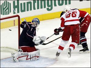 The Red Wings' Tomas Holmstrom slips the puck past Blue Jackets goalie Steve Mason in the first period. Detroit got the game-winning goal from Johan Franzen with 46.6 seconds left.
