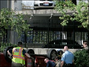 CTY  garage28p 04/27/09  The Blade/Dave Zapotosky Caption: Toledo police and  fire officials investigate the scene after a car drove off of the parking garage at St. Vincent Mercy Medical Center, in Toledo, Ohio, Monday, April 27, 2009.  There was one female occupant who was taken from the vehicle. Summary: Car drives off of the parking garage at St. Vincent Mercy Medical Center.