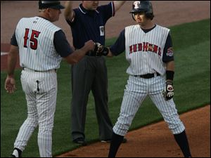 The Mud Hens  Jason Tyner is congratulated by manager Larry Parrish after smacking a triple
against Columbus at Fifth Third Field. The Hens had 12 hits, fi ve of them for extra bases.