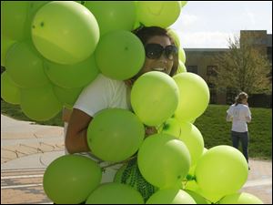 CTY balloons28p  [The balloons were not released, but used to draw attention to the event and the opportunity to sign up to be an organ donor.]   Junior Sara (cq) Newell, 21, a Public Relations major and one of the event's organizers, gets wrapped up by the windblown balloons. As part of the Donate Life and the Do It Now campaign, Bowling Green State University students solicit others on the campus to become an organ donor, on the Bowling green, Ohio campus on April 27, 2009. The "What are you w8ing for?" campaign team, along with other high-profile volunteers and community members, will be releasing 3,000 balloons at the BGSU Union Oval at 10:30 a.m. in an effort to bring attention to organ and tissue donation. Each balloon represents one of the 3,000 Ohioans currently waiting for a life-saving transplant. The Blade/Jetta Fraser