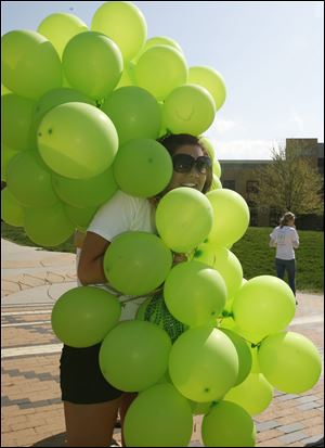 CTY balloons28p  [The balloons were not released, but used to draw attention to the event and the opportunity to sign up to be an organ donor.]   Junior Sara (cq) Newell, 21, a Public Relations major and one of the event's organizers, gets wrapped up by the windblown balloons. As part of the Donate Life and the Do It Now campaign, Bowling Green State University students solicit others on the campus to become an organ donor, on the Bowling green, Ohio campus on April 27, 2009. The 