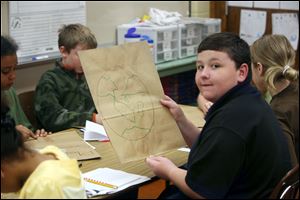 Fourth-grader Austin Nuhfer displays the grocery bag he decorated with a conservation theme. His bag and others will go back to the donor store, encouraging customers to conserve resources. 