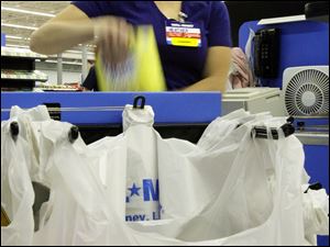 Wal-Mart cashier Heather Martin bags purchases in Los Angeles yesterday.