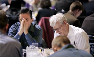 Steve Detmer of Sylvania, left, and Steve Bartus of Toledo bow their heads in prayer at the 20th Annual Northwest Ohio Prayer Breakfast. Motivational speaker and author John Maxwell, a former pastor, gave the keynote speech at yesterday's event at the SeaGate Convention Centre in Toledo. Maxwell