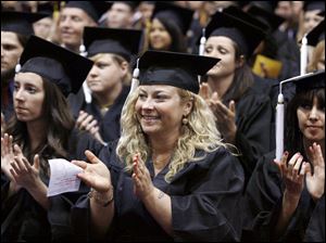 Slug: CTY OWENSGRAD08P C         The Blade/Jeremy Wadsworth  Date: 05/08/09  Caption: Heather Puhy of Maumee celebrates graduating with an Associate degree of Arts Friday, 05/08/09, at Owens Community College.