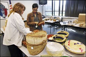Theresa Ashton, left, and Tanya Seldon, both of Toledo, examine some of the baskets that were on sale at the Catholic Center this week. 