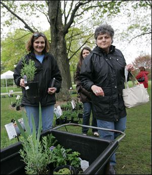 Audrey Laux, left, of Sylvania, and Sylvie Knick of North Royalton, Ohio, center, visit the botanical garden plant sale with their mom, Regine Knick of Lima, to prepare to celebrate Mother s Day