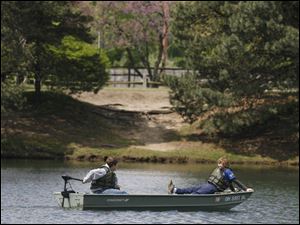 Slug: CTY olander11p         The Blade/Jeremy Wadsworth  Date: 05/10/09  Caption: Left Jacob Holloway, 12, of Sylvania, and Colton Snider, 13, of Sylvania ride a boat around  Lake Olander Sunday, 05/10/09, during the "Sail the Seas or Drop a Line"  event at Olander Park in Sylvania.  NOTE: THESE WERE THE ONLY PEOPLE AT THIS EVENT AT THIS TIME. I STAYED CLOSE TO AN HOUR.