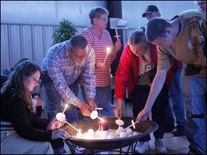Members of the late Henrietta Foster s family including her daughter, Karen, left, light candles in remembrance of her during a vigil last night at the Perrysburg Heights Community Center organized by the Cocoon Shelter for battered women and their children and the Perrysburg Heights Community Association. Ms. Foster was found slain in her home April 19. 