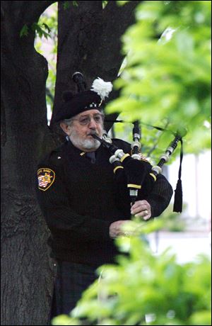 Walter Metcalfe of the Lucas County Sheriff's Office plays the bagpipes at the memorial service. 