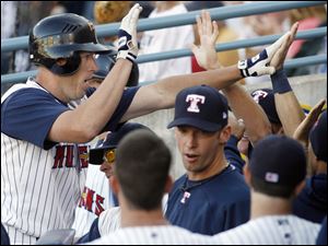 Toledo's Mike Hessman, left, high-fives teammates after he belted a two-run homer last night at Fifth Third Field.