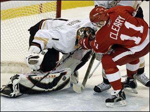 The Red Wings  Dan Cleary stuffs the winning shot past Ducks goalie Jonas Hiller.