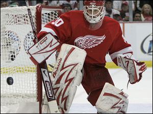 Red Wings goalie Chris Osgood deflects a shot during the first period. Detroit took a 2-0 series lead over the Blackhawks with a 3-2 overtime victory in Game 2 of the Western Conference finals.