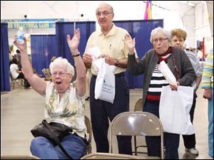 Rose Tiller, left, of Temperance celebrates herhusband s skill with the Nintendo Wii Fit game as Paul and Betty Lehman of Toledo watch at the 32nd annual Senior Day Spring Fling, at the Lucas County Recreation Center yesterday.