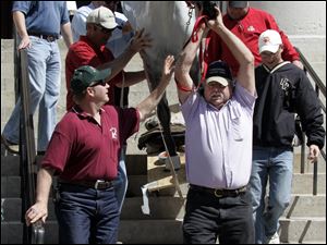 Mike Woebkenberg, holding the reins, gets help removing his model horse from the Ohio Statehouse after the rally.