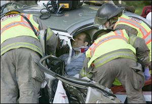 Toledo firefighters work to free a man pinned in his car following a crash on Heatherdowns Boulevard in South Toledo on Wednesday morning.  This man and a woman from another vehicle involved in the crash were transported to a hospital.