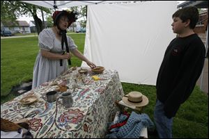 Sherri Howard of Monroe talks to a visitor about the medicines of the period.