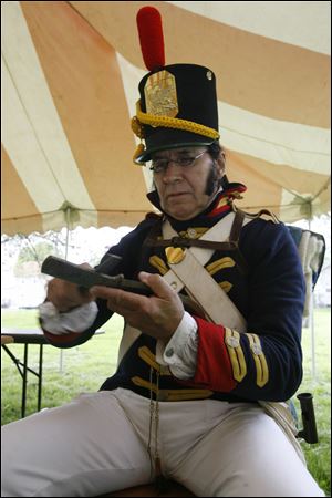 Re-enactor Kenneth Roberts of St. Claire Shores, Mich., sharpens a knife while wearing a United States Marines uniform during the recent annual open house at the visitors  center at the River Raisin Battlefield in Monroe.