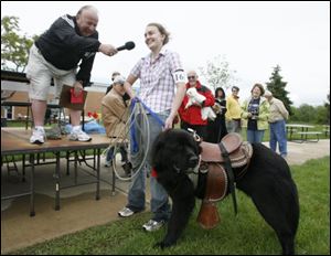 David E. Nixon, president of Monroe County Community College, interviews Brandy Werner, who entered her dog, Amos, a Newfoundland-St. Bernard mix, in the costume category at a recent dog show at the school. The event aimed to raise money for Project Second Chance, which gives children at the county youth center the chance to work and train dogs from the Monroe County Humane Society.