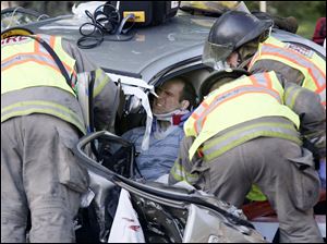 Toledo firefighters remove an unidentified driver who was pinned in one of three cars involved in a crash in the 3700 block of Heatherdowns Boulevard about 7:30 yesterday morning. The driver of the second vehicle, a woman, also had to be extricated by emergency personnel. Both were taken to the University of Toledo Medical Center, formerly the Medical College of Ohio Hospital, with serious injuries. The third driver, a woman, also was taken to an area hospital. The crash remains under investigation. Identities of the injured were unavailable.