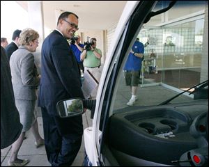 Ed Montgomery, the federal director of recovery for auto communities and workers, surveys a hybrid car during his visit.