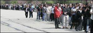 Area unemployed workers stand in line at the Toledo Job Fair earlier this month.