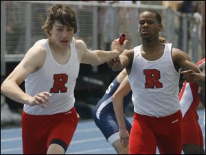 Craig Short of Rogers, left, grabs the baton from teammate Adrian Awls in the 1600 relay. 