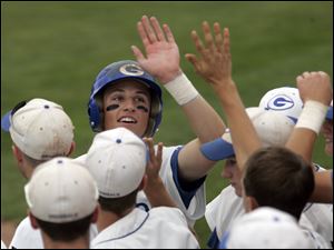 Anthony Wayne's Sam Fischer is greeted by teammates after scoring a run against St. Francis.