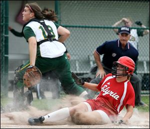 Elyria's Kristen Fyffe scores after a throw home sails over the head of Clay catcher Sarah Stibaner (18) in the D-1 regional softball final.