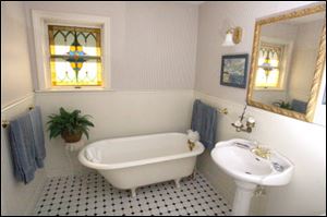 The bathroom has a vintage-style clawfoot tub, sink, and floor.