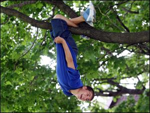 Slug: ROV treeclimb            Date 6/2/2009           The Blade/ Amy E. Voigt              Location: Toledo, Ohio  CAPTION:  East Side Central Elementary School student John Perez hangs upside down on a small tree in Navarre Park while on an outing with their sixth grade class. The kids were allowed to dress down (not wear their uniforms), have ice cream at Deb's Soft Kreme, and play in the park on the day before their last day of school.