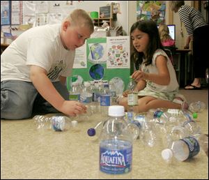 NBRN recycle03p  The Blade/Lisa Dutton 05_27_2009 Monroe,MI l to r-Eight year old Alec Neidinger and 7 year old Liliana Kurutz count plastic bottles that the class has been recycling.  The second graders in Kim Pearch's class have been collecting plastic water bottles since April as part of recycling project. THey are using a website to calculate the number of shirts that the collected bottles will make.