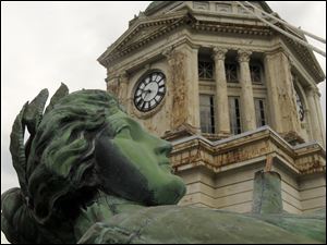 Eyes heavenward, the statue rests on the roof of the Wyandot County Courthouse en route to the top of the clock tower. It was secured on the dome Monday after undergoing restoration. 
