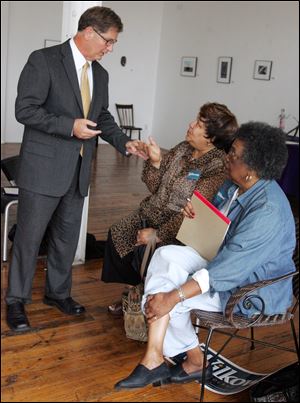 Toledo mayoral candidate Keith Wilkowski, one of the Democrats competing in the Sept. 15 primary, speaks to Diane Gordon, left, and Twyla Wheaton at MMK Gallery on North St. Clair Street, where he announced plans yesterday to address women s issues. He vowed that women would hold key  positions at every level of city government if he is elected.