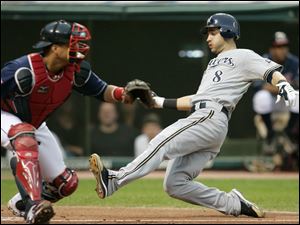 Milwaukee's Ryan Braun slides safely into home before Indians catcher Victor Martinez can make the tag.