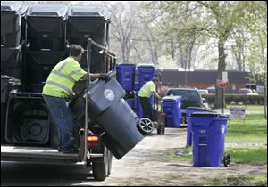New trash cans are dropped off in anticipation of automated refuse collection.