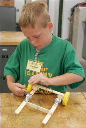 Nine-year-old Nick Nopper prepares his car for competition. In addition to robotics, the children learned about rockets and solar energy.  Local doctor Erol Riza funded the program. 