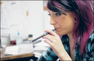 Sara Jacobs smokes an InLife electronic cigarette in her office during work.
