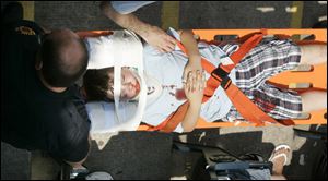 Eight year-old Pierce Mitchell, of Hudson, Michigan is taken to St. Vincent's Mercy Medical Center by Toledo Fire Department personnel after he was hit in the head with a broken bat.