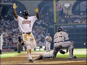 Houston's Michael Bourne (21) scores on a single by Carlos Lee while Detroit catcher Dusty Ryan, right, waits for the throw during the first inning. The Astros beat the Tigers to clinch the series.