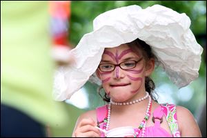 Emily Brandeberry, 8, of Maumee fashioned a paper hat that's the perfect complement to pearls and a painted face.