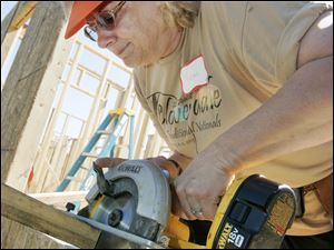 NBRE habitat01p  06/26/09  The Blade/Dave Zapotosky Caption: Vicki Shutters of Swanton cuts a board at a Habitat for Humanity build on Ansonia St. in Oregon, Ohio, Friday, June 26, 2009.  Two homes were being constructed by a large group of volunteers including some from five are religious congregations, the United Way Women's Initiative, and the National Association of Women in Construction (NAWIC), Toledo Chapter.   Summary: Habitat for Humanity build in Oregon.