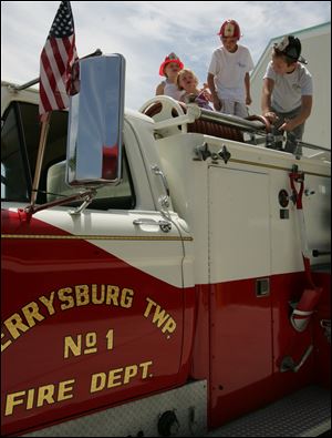 NBRS fire01p  06/27/2009     The Blade/Lori King  from left: Keely Mirrick, 5, Ailey Mirrick, 3 and Aidan Mirrick, 8, and Noah Brice, 9, play on top of a fire truck during open house of the new Perrysburg Township Fire Dept. station in Perrysburg Township, OH.