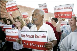 Kylie Moore, left, and Norman A. Bell, Sr., gather during a Help Seniors Remain at Home rally at Margaret Hunt Senior Center.